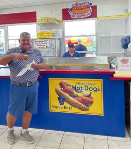 Customer eating a hot dog at weenie at the wash